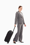 Businesswoman wheeling a suitcase