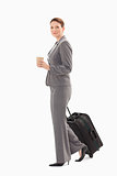 Businesswoman walking with coffee and suitcase