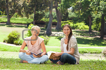 Friends sitting with their books in the park