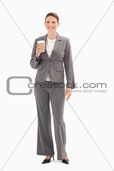 Smiling businesswoman holding cup of coffee 