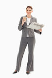 Smiling businesswoman holding cup and newspaper