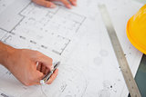 Close up of blueprints with a person making adjustments