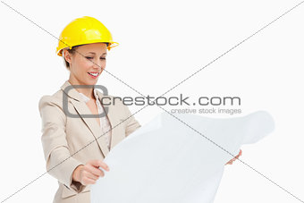 Smiling woman in a suit looking plans