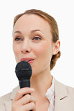 Woman in a suit speaking with a microphone 