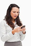 Brunette grimacing while looking her text message