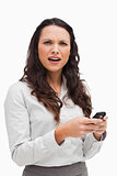 Portrait of a brunette grimacing while looking her text message