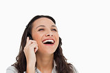 Brunette laughing while making a call