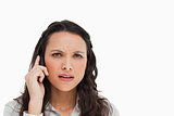 Portrait of a brunette grimacing while making a call