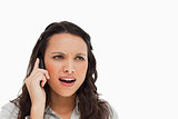 Brunette grimacing while making a call