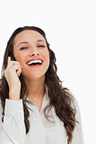 Portrait of a pretty brunette laughing while phoning 