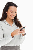 Brunette smiling while using her mobile