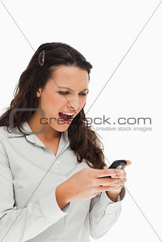 Brunette frowning while using her mobile