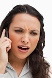 Close-up of a brunette frowning while phoning