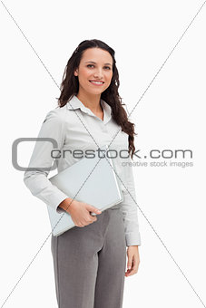 Brunette standing while holding a laptop 
