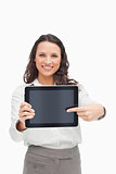 Portrait of a brunette showing and pointing a touchpad screen