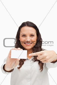 Brunette showing and pointing a card