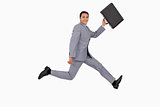 Portrait of a businessman running with a suitcase