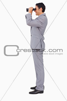 Profile of a businessman using binoculars 