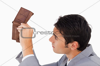 Man in a suit looking in his empty wallet 
