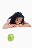 A green apple with a smiling girl in the background