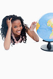 A young girl with her and on a globe