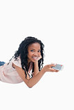A young girl holding a television remote control is smiling at t