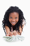 A smiling woman is holding American dollars out in front of her