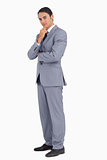 Thoughtful businessman smiling with folded arms
