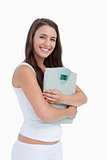 smiling young woman holding a weighing scales 