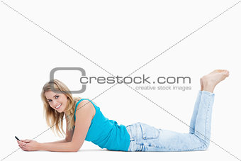 A woman lying on the floor with her legs held up is holding her 