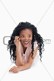A front view shot of a surprised young girl talking on her mobil