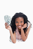 A woman resting her head on her hand is holding Americn dollars