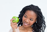 A woman is looking at an apple she is holding