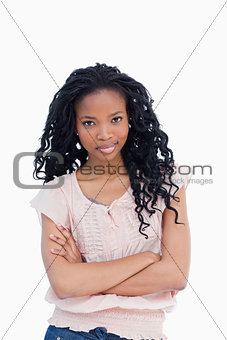 A woman with her arms folded is staring at the camera