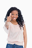 A girl is smiling and giving a thumb up