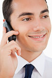 Close-up of a smiling man in a suit using his cellphone