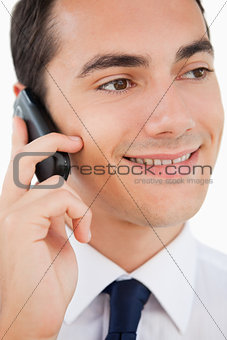 Close-up of a smiling man in a suit using his cellphone