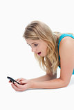 A surprised young woman is looking at her mobile phone