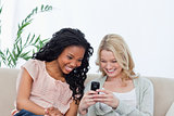 A woman is showing her friend her mobile phone