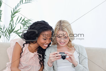 Two women look at photos on a digital camera