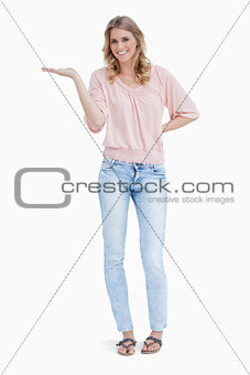 Woman smiling at the camera with the palm of her hand held up fl