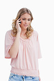 Young blonde woman is talking on her mobile phone