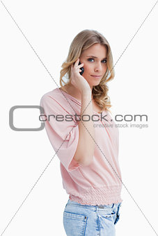 Woman talking on her mobile phone is looking at the camera