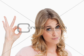 Relaxed young woman showing the ok sign