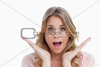 Surprised young woman raising her hands
