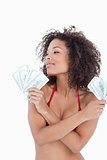 Young attractive woman looking away while holding bank notes