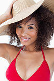 Smiling woman looking at the camera while holding her hat