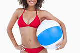 Smiling brunette woman holding a beach ball