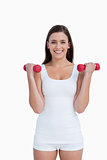 Smiling woman looking at the camera while holding dumbbells