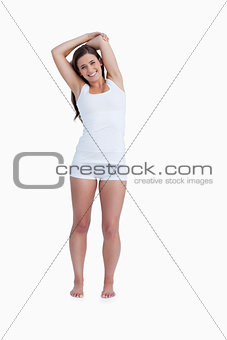 Smiling woman standing with arms crossed above her head